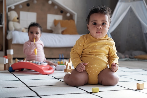 Bebés gemelos sentados en el suelo