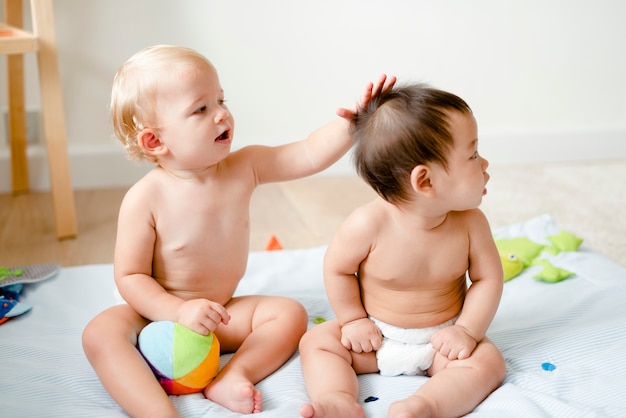 Bebés en pañales jugando juntos