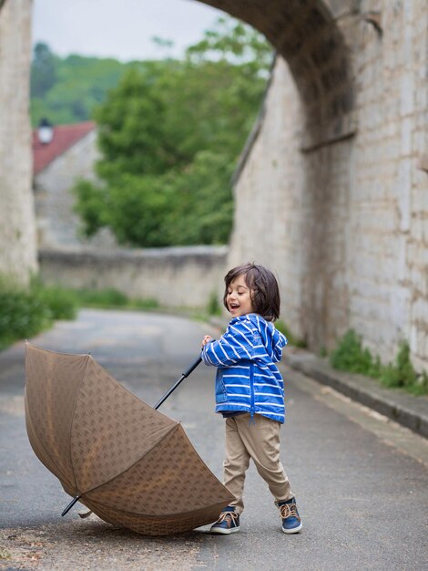 Bebezinho bonito brincando com guarda-chuva ao ar livre