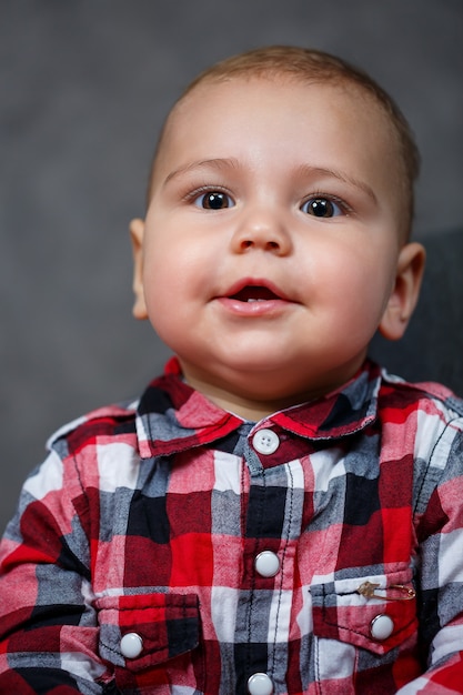 Foto bebezinho com camisa no fundo cinza sorri lindamente