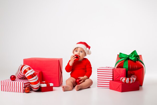 Bebezinho fofo fantasiado de papai noel com presentes