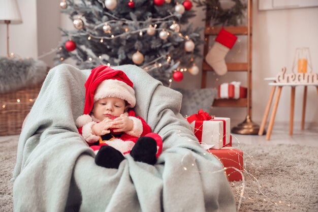 Bebezinho fofo fantasiado de Papai Noel em casa