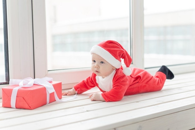 Bebezinho lindo celebra o Natal. Feriados de ano novo. Bebê com fantasia de Natal e em