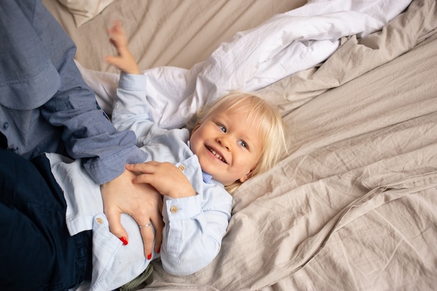 Bebezinho na cama com os pais a divertir-se