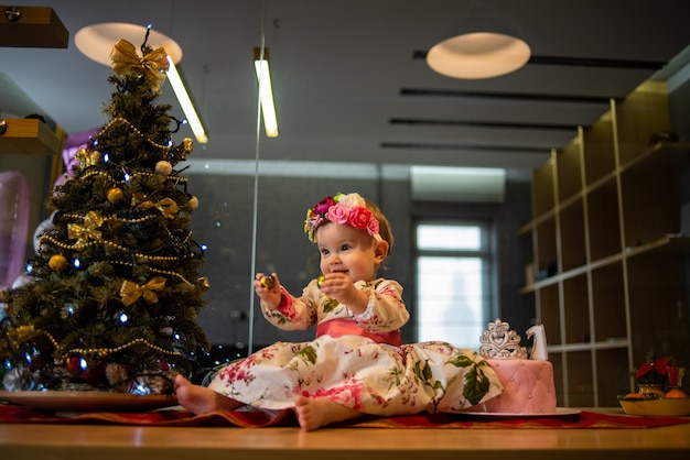 Bebezinho perto da árvore de natal antes da festa de ano novo