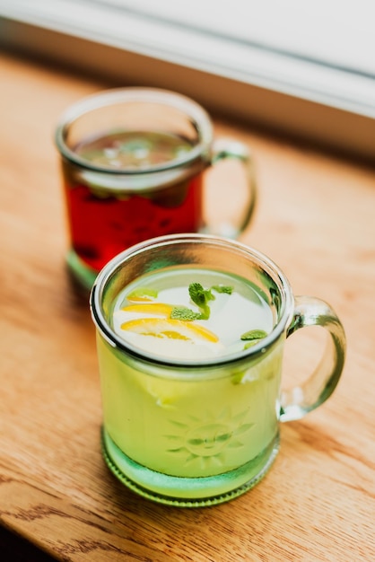 Una bebida alcohólica caliente con menta y limón en una taza de vidrio