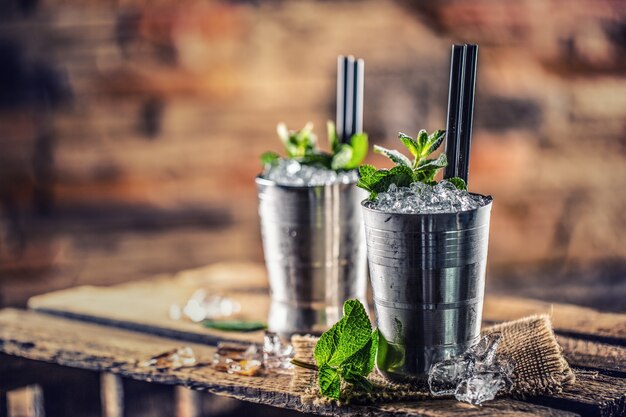 Bebida alcohólica cóctel de julepe de menta sobre tabla de madera en pub o restaurante.