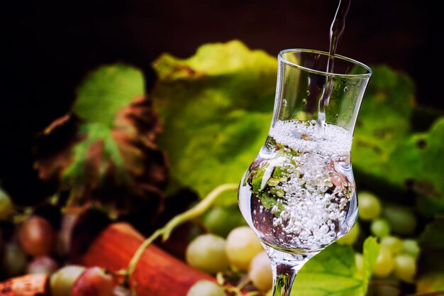 Bebida alcohólica fuerte que se vierte en vaso de chupito Bodegón rústico Enfoque selectivo