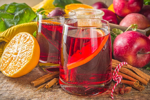 Bebida alcohólica tradicional de otoño invierno. Sangría afrutada de otoño caliente con cítricos, manzanas y especias, fondo rústico de madera