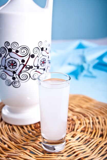 Bebida alcoólica ouzo tradicional grega anice raki em shot com uma garrafa próxima