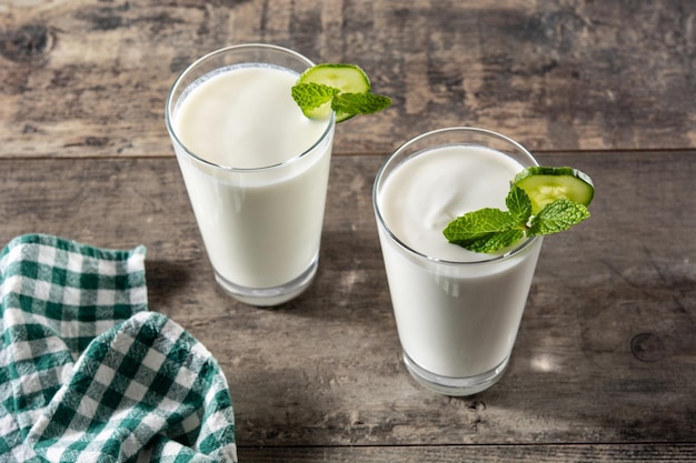 Bebida ayran com hortelã e pepino em vidro na mesa de madeira