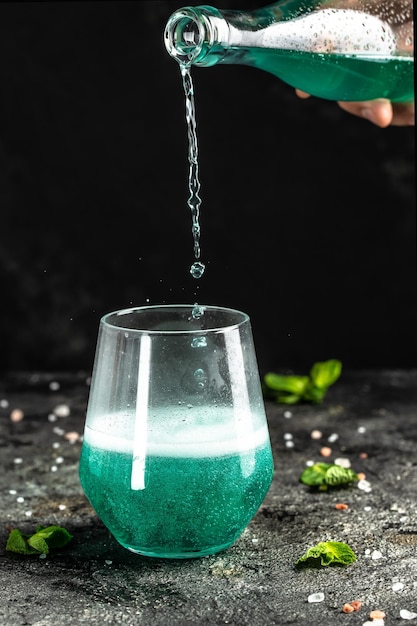 Bebida azul com baixo teor de álcool bebidas coloridas geladas na festa de verão de fundo preto rústico Conceito de bebida alcoólica Congele gotas de movimento em respingos líquidos