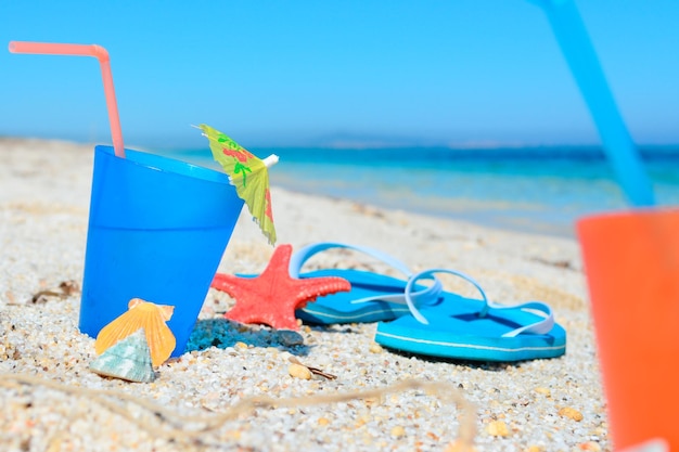 Bebida azul com sandálias em uma costa tropical