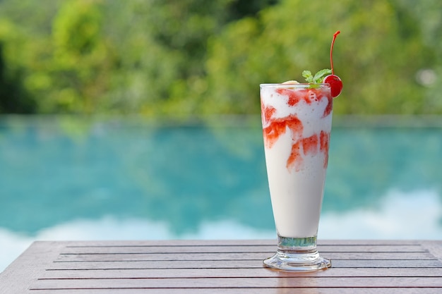 Bebida de batidos fríos de vacaciones en la piscina. Copiar el espacio