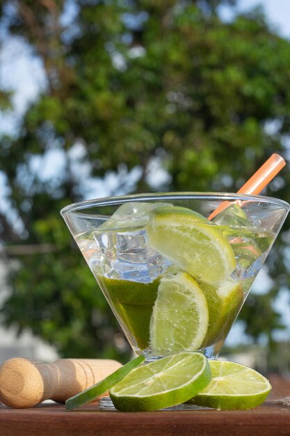 Foto bebida brasileña caipirinha en la mesa con ingredientes en un día soleado