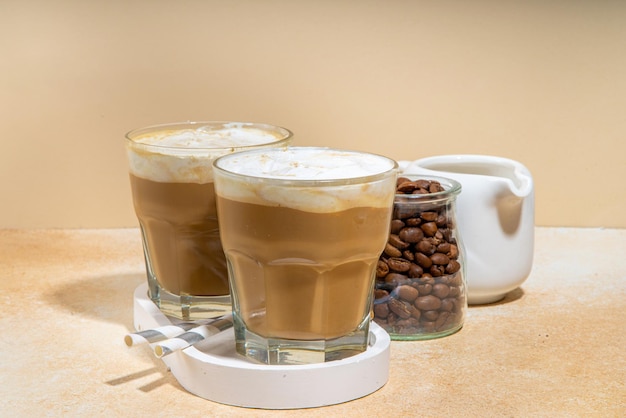 Bebida de café lácteo frío con crema batida de leche Capuchino frappe latte espumoso en un espacio de fondo crema para texto Cóctel de café frío de verano