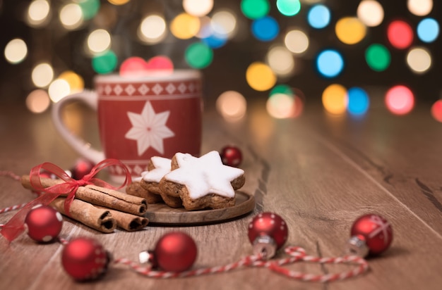 Bebida caliente, galletas navideñas y bastón de caramelo sobre la mesa