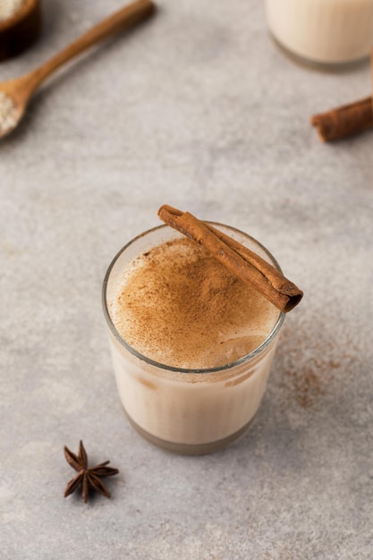 Bebida caseira de arroz Horchata em um copo com gelo e canela em um fundo cinza de concreto