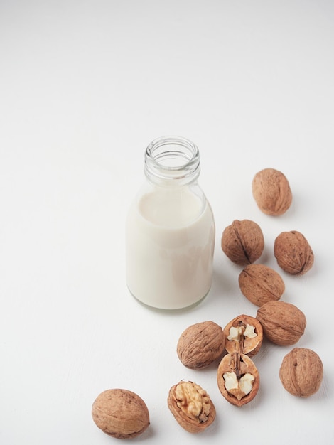 Foto bebida casera de nueces vegetales leche vegana sin lactosa en botella de vidrio y avellanas