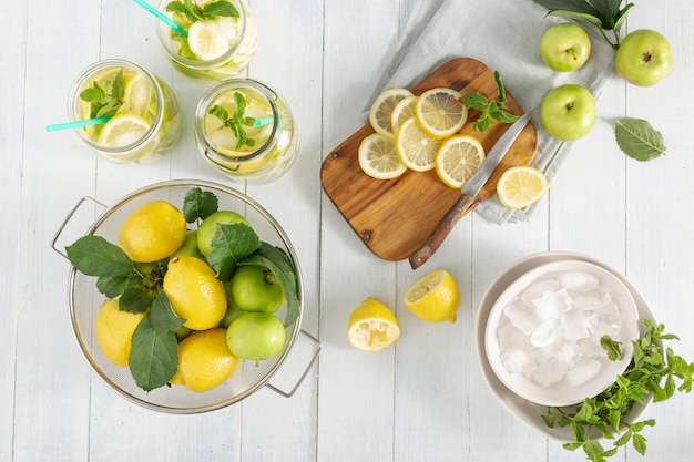 Foto bebida de cítricos. limonada fresca con manzanas y limón en la vista superior de la mesa de madera