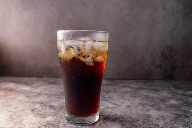 Bebida de cola en un vaso con hielo