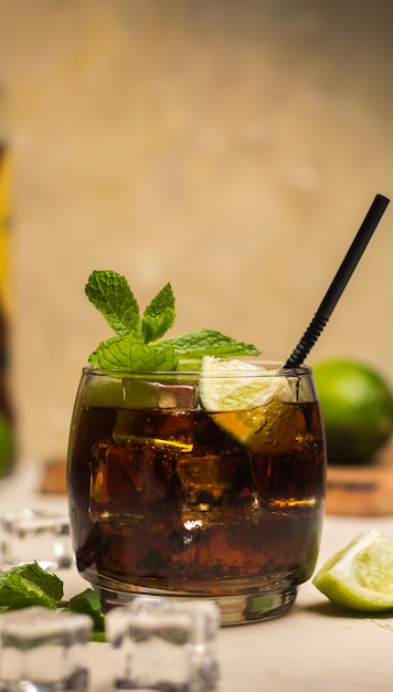 Bebida Cuba Libre con hojas de menta y trozos de lima.