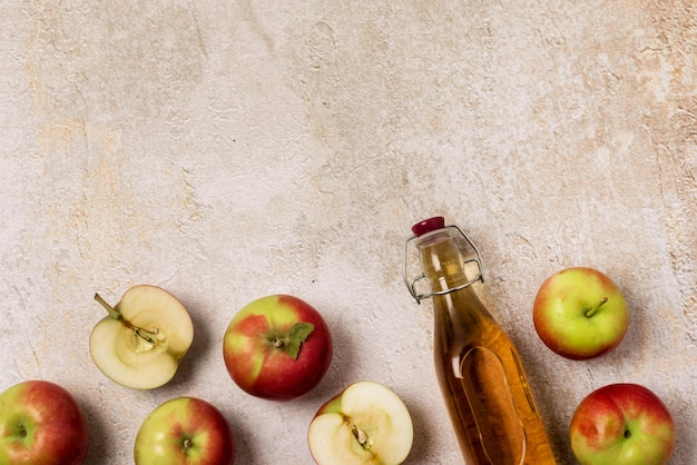 Foto bebida de cidra de maçã ou bebida de fruta fermentada e maçãs orgânicas em fundo de concreto alimentação saudável