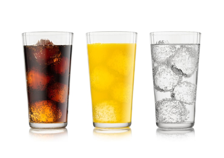 Foto bebida de cola com limonada e refrigerante de laranja com cubos de gelo e bolhas em branco