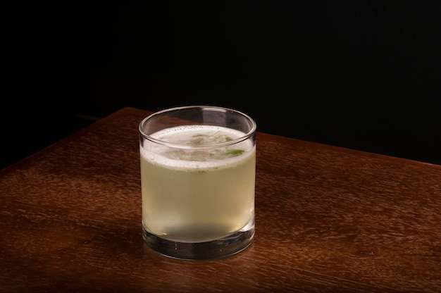 Bebida de coquetel de gin de limão e gengibre no canto de uma vista de ângulo de mesa de madeira