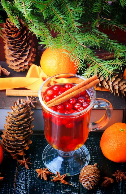 Bebida de cranberry quente canela galhos de árvore de natal fundo ponche de inverno