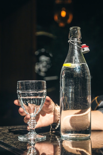 Bebida de garrafa de água com vidro na mesa no restaurante