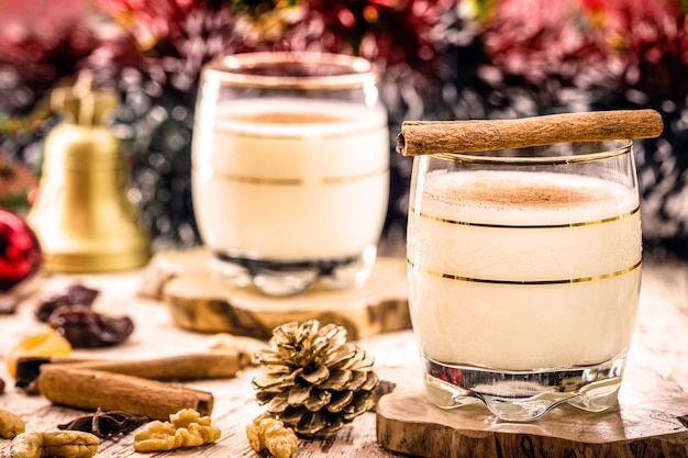 Bebida de inverno feita com ovos, licor, rum e canela, chamada gemada de Natal, decorada com nozes, biscoitos e frutas secas