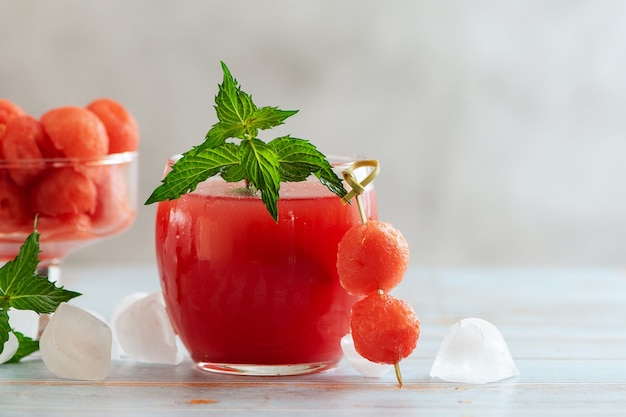 Bebida de melancia em vidro e bolas de melancia. um refrescante coquetel de verão.