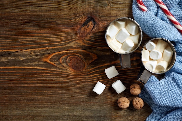 Bebida de Natal. Caneca de café quente com marshmallow, pirulito vermelho sobre o fundo de madeira. Ano Novo. Cartão de férias. Estilo rústico. Vista superior e copie o espaço.. Ano novo 2018