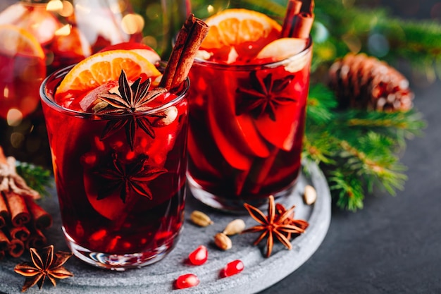 Bebida de Natal sangria ou vinho quente com maçãs laranjas romã e paus de canela