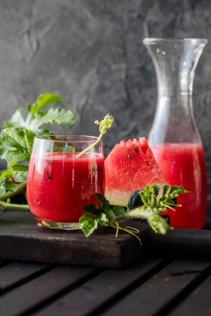 Bebida de verão Suco de melancia com limão e hortelã em uma placa de madeira Batido de frutas vermelhas