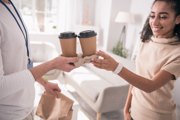 Bebida deliciosa. Cerca de tazas con café que se le da a una joven alegre