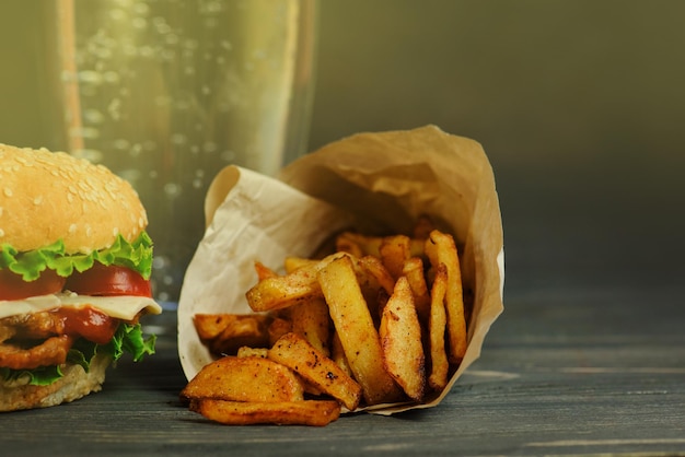 Bebida doce carbonatada em um copo e salgadinhos de hambúrguer chips pretzels