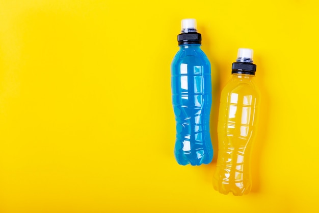 Bebida energética isotônica. Garrafa com líquido transparente azul e amarelo, bebida esportiva