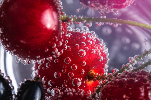 Bebida fresca y fría de agua con gas con cerezas