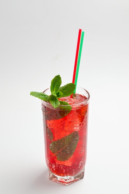 Bebida fresca vermelha com gelo, toranja e hortelã isoladas em branco. Espaço para texto ou design.