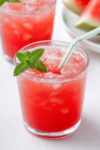 Bebida fría de verano con sandía y menta sobre un fondo de madera