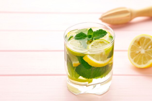 Bebida gelada de limonada fresca em um fundo rosa com espaço de cópia