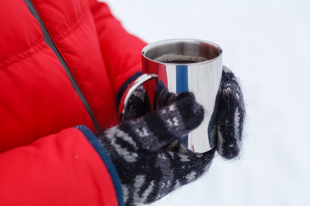 Bebida de invierno caliente en la nieve en el bosque