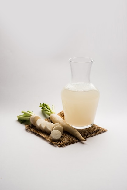 Bebida de jugo de daikon fresco saludable o extracto de Mooli en un vaso con mula cruda