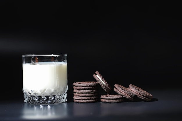 Bebida láctea en un vaso. Leche de granja y galletas. Delicioso snack con leche de vaca y bollería recién horneada.