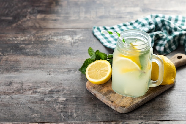 Bebida de limonada en un frasco de vidrio e ingredientes en una mesa de madera