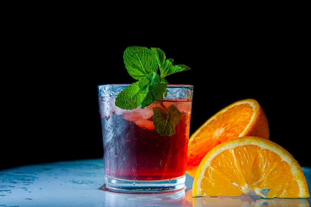 Bebida de limonada roja fresca con naranja menta y hielo en frasco de vidrio sobre el fondo oscuro Bebida fría de verano y cóctel