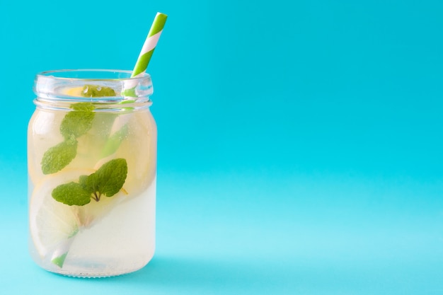 Bebida de limonada en un vaso jarra en espacio de copia azul