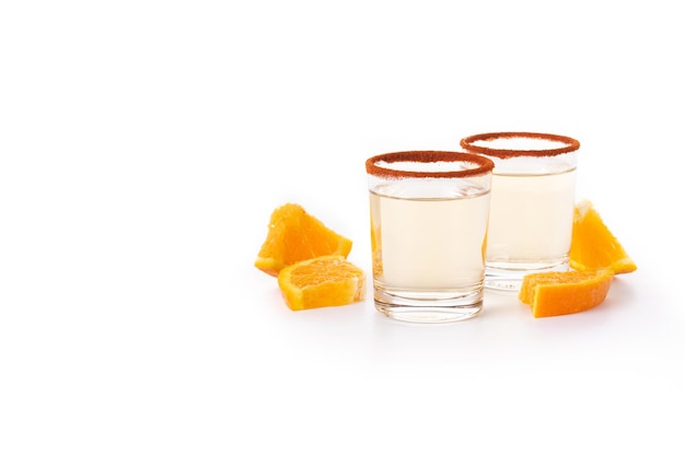 Bebida mexicana de mezcal com fatias de laranja e sal de minhoca isolado no fundo branco